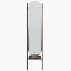 a tall mirror sitting on top of a wooden stand