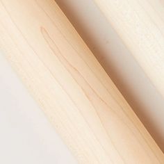 closeup of two wooden baseball bats on a white surface