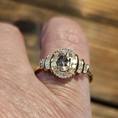 a woman's hand with a ring on it that has three stones in the middle