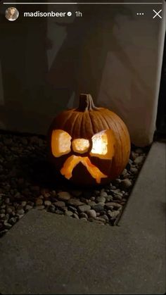 a carved pumpkin with a bow on it's head sitting in front of a door