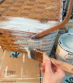 someone is painting the inside of a basket with brown and white paint on top of it