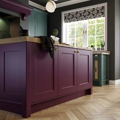 a kitchen with purple cabinets and wooden floors