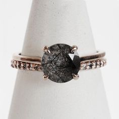 a black diamond ring on top of a white vase