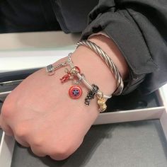 a person's arm with three bracelets on it and an iron man charm