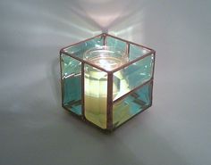 a glass candle holder with a lit candle inside