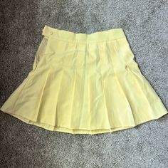 Baby Yellow Pleated Tennis Skirt, With Zipper And Button Detail On The Side Fitted Skirt With Button Zip Fly For Spring, Fitted Summer Skirt With Button Zip Fly, Fitted Pleated Skirt With Buttons For Spring, Retro Pleated Skirt For School In Spring, Yellow School Skirt For Spring, Preppy Skort With Pockets For Spring, Yellow Pleated Tennis Skirt For Spring, Retro Spring Tennis Skirt With Lining, Spring Yellow Pleated Tennis Skirt