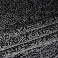 black and white fabric with an intricate design on the front, in shades of grey