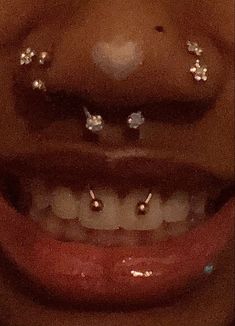 a woman's smile with diamond studs on her nose and lower lip area