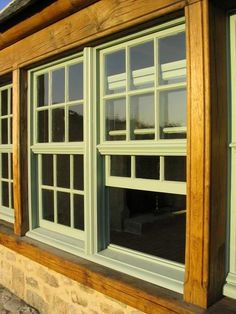 an open window on the side of a building with wood trim and glass panes