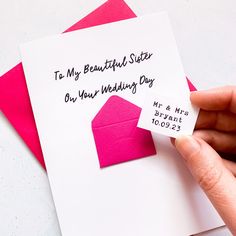 a hand holding a wedding card with the words to my beautiful sister on your wedding day