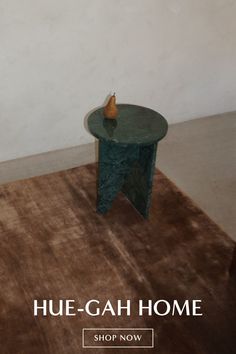 a table with a vase sitting on top of it in front of a white wall