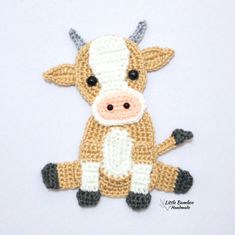 a crocheted cow is sitting on the floor with its legs crossed and eyes wide open