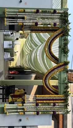 an overhead view of a building with flowers on the outside and yellow ribbons hanging from it's sides