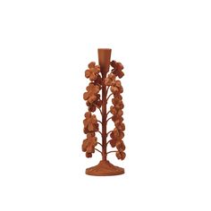 a wooden vase with flowers and leaves on the top is standing in front of a white background