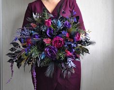 a bouquet of purple flowers sitting on top of a white chair