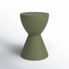 a green vase sitting on top of a white table