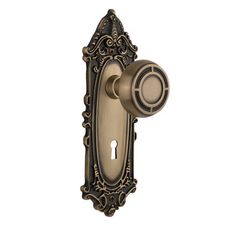 an antique style door handle with a keyhole and ornate scroll design on the front