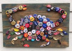 a wooden sign with many different types of beer bottle caps on it, all in the shape of a crab