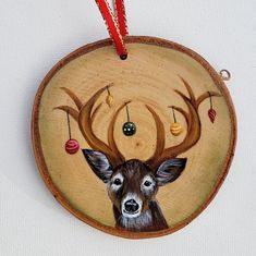 a wooden ornament with a deer's head painted on it