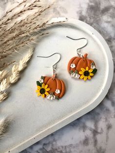 a pair of earrings with sunflowers on them