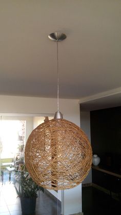 a light fixture hanging from the ceiling in a room with tile flooring and white walls