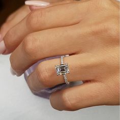 a woman's hand with a ring on her finger and a diamond in the middle