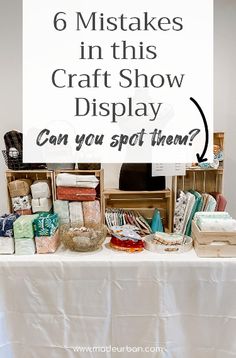 a white table topped with lots of crafting supplies and a sign that says 6 mistakes in this craft show display can you spot them?