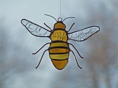 a glass bee ornament hanging from a wire