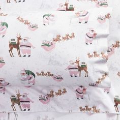 a white sheet with pink and green christmas reindeers on it's back side