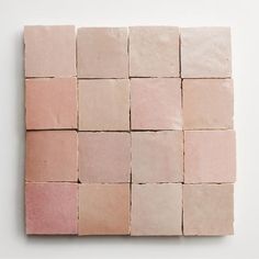 several square tiles arranged on top of each other in pink and beige colors, with one block missing the middle