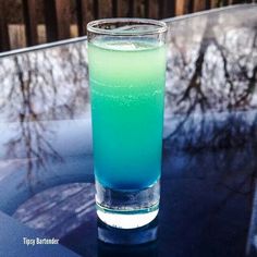 a blue and green drink sitting on top of a table