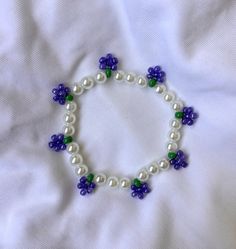 a white bracelet with blue and green beads