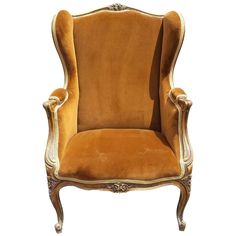 an old fashioned chair with gold velvet upholstered on the back and arms,