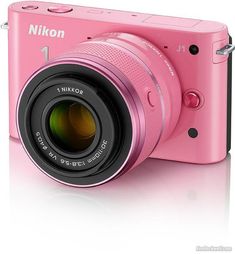 a pink digital camera sitting on top of a white surface