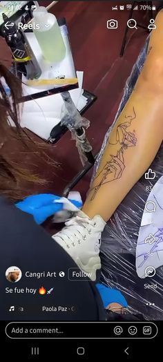 a person with a tattoo on their arm sitting in front of a chair and holding scissors