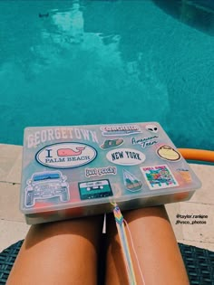 a person sitting next to a swimming pool with stickers on it