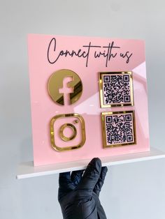 someone is holding up a pink card with qr code on it and gold accents