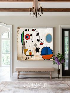 an abstract painting hangs on the wall above a bench in front of a large doorway