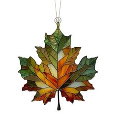 a stained glass leaf ornament hanging from a chain