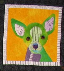 a close up of a quilt with a dog on it's face and eyes