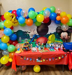 a mickey mouse themed birthday party with balloons