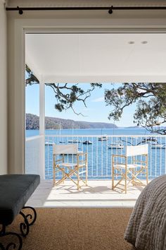 a bedroom with a balcony overlooking the water