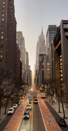 a city street filled with lots of traffic next to tall buildings