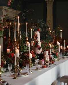 a long table with candles and flowers on it is set up for a formal dinner