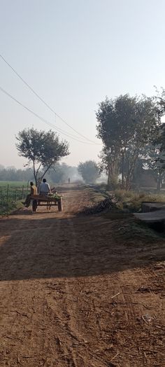 a man driving a tractor down a dirt road