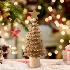 a small wooden christmas tree sitting on top of a table next to a toy santa clause