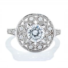 a diamond ring with an intricate design on the center and sides, surrounded by round brilliant cut diamonds