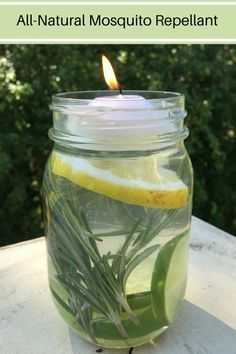 a candle that is in a jar with some water and lemon slices on the table