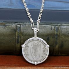 This is a custom order item. Your order will ship within 3-5 business days of payment confirmation. The coin pendant in the listing photos is an example of the finished piece. Excluding the year on the coin, your coin pendant will be the same design as the pictured pendant. Each pendant setting is made by hand (not a machine), and no two coins are exactly alike. If you are looking for a specific year, let me know, I may have it in my collection. This Irish Three Pingin rests in a handcrafted set Heirloom Silver Necklace With Coin Pendant, Classic Sterling Silver Necklace With Coin Pendant, Handmade Sterling Silver Necklace For Commemoration, Antique Stamped Sterling Silver Necklace, Handmade Coin-shaped Sterling Silver Necklace, Classic Hallmarked Antique Silver Necklace, Classic Hallmarked Sterling Silver Custom Necklace, Vintage Sterling Silver Jewelry For Commemoration, Heirloom Sterling Silver Round Pendant Necklace