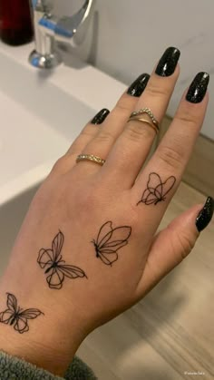 a woman's hand with tattoos on it and a butterfly tattoo on the wrist